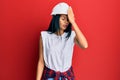 Young african american woman wearing architect hardhat surprised with hand on head for mistake, remember error Royalty Free Stock Photo