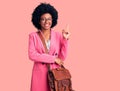 Young african american woman wearing business clothes and leather bag smiling happy pointing with hand and finger to the side Royalty Free Stock Photo