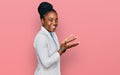 Young african american woman wearing business clothes pointing aside with hands open palms showing copy space, presenting Royalty Free Stock Photo