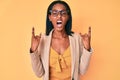 Young african american woman wearing business clothes shouting with crazy expression doing rock symbol with hands up Royalty Free Stock Photo