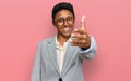 Young african american woman wearing business clothes smiling friendly offering handshake as greeting and welcoming Royalty Free Stock Photo