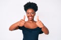 Young african american woman wearing casual clothes approving doing positive gesture with hand, thumbs up smiling and happy for Royalty Free Stock Photo