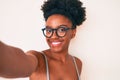 Young african american woman wearing casual clothes and glasses making selfie by the camera looking positive and happy standing Royalty Free Stock Photo