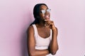 Young african american woman wearing casual clothes and glasses smiling looking confident at the camera with crossed arms and hand Royalty Free Stock Photo