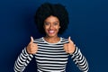 Young african american woman wearing casual clothes success sign doing positive gesture with hand, thumbs up smiling and happy Royalty Free Stock Photo