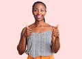 Young african american woman wearing casual clothes success sign doing positive gesture with hand, thumbs up smiling and happy Royalty Free Stock Photo