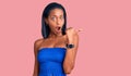 Young african american woman wearing casual summer clothes surprised pointing with hand finger to the side, open mouth amazed Royalty Free Stock Photo