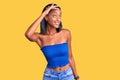 Young african american woman wearing casual summer clothes very happy and smiling looking far away with hand over head Royalty Free Stock Photo