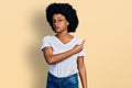 Young african american woman wearing casual white t shirt pointing with hand finger to the side showing advertisement, serious and Royalty Free Stock Photo