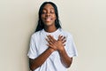 Young african american woman wearing casual white t shirt smiling with hands on chest, eyes closed with grateful gesture on face Royalty Free Stock Photo