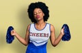 Young african american woman wearing cheerleader uniform using pompom looking at the camera blowing a kiss being lovely and sexy