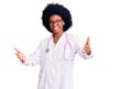 Young african american woman wearing doctor coat and stethoscope looking at the camera smiling with open arms for hug Royalty Free Stock Photo