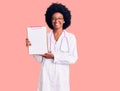 Young african american woman wearing doctor stethoscope holding clipboard looking positive and happy standing and smiling with a Royalty Free Stock Photo