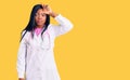 Young african american woman wearing doctor stethoscope making fun of people with fingers on forehead doing loser gesture mocking Royalty Free Stock Photo