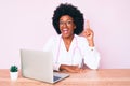 Young african american woman wearing doctor stethoscope working using computer laptop pointing finger up with successful idea Royalty Free Stock Photo