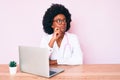 Young african american woman wearing doctor stethoscope working using computer laptop serious face thinking about question with Royalty Free Stock Photo