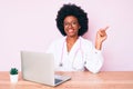 Young african american woman wearing doctor stethoscope working using computer laptop smiling happy pointing with hand and finger Royalty Free Stock Photo