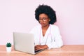 Young african american woman wearing doctor stethoscope working using computer laptop thinking attitude and sober expression Royalty Free Stock Photo