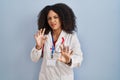 Young african american woman wearing doctor uniform and stethoscope disgusted expression, displeased and fearful doing disgust