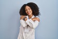 Young african american woman wearing doctor uniform and stethoscope hugging oneself happy and positive, smiling confident Royalty Free Stock Photo