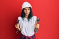 Young african american woman wearing hardhat holding wrench relaxed with serious expression on face Royalty Free Stock Photo