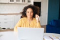 Young African-American woman wearing headset using laptop for remote work