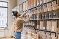 Young african american woman wearing mask buying cereals and grains in sustainable zero waste grocery store Royalty Free Stock Photo