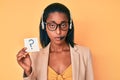 Young african american woman wearing operator headset holding question mark thinking attitude and sober expression looking self Royalty Free Stock Photo