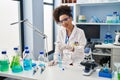 Young african american woman wearing scientist uniform using pipette working at laboratory Royalty Free Stock Photo