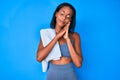 Young african american woman wearing sportswear sleeping tired dreaming and posing with hands together while smiling with closed Royalty Free Stock Photo