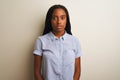 Young african american woman wearing striped shirt standing over isolated white background with serious expression on face Royalty Free Stock Photo