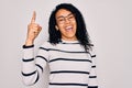 Young african american woman wearing striped sweater and glasses over white background pointing finger up with successful idea Royalty Free Stock Photo