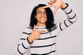 Young african american woman wearing striped sweater and glasses over white background smiling making frame with hands and fingers Royalty Free Stock Photo