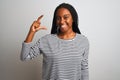 Young african american woman wearing striped t-shirt standing over isolated white background smiling and confident gesturing with Royalty Free Stock Photo