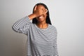 Young african american woman wearing striped t-shirt standing over isolated white background smiling and laughing with hand on Royalty Free Stock Photo