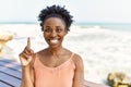 Young african american woman wearing summer clothes standing at the beach surprised with an idea or question pointing finger with Royalty Free Stock Photo