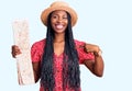 Young african american woman wearing summer hat holding city map pointing finger to one self smiling happy and proud Royalty Free Stock Photo