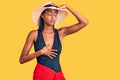 Young african american woman wearing swimsuit and summer hat touching forehead for illness and fever, flu and cold, virus sick Royalty Free Stock Photo