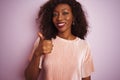 Young african american woman wearing t-shirt standing over isolated pink background doing happy thumbs up gesture with hand Royalty Free Stock Photo