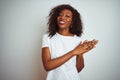 Young african american woman wearing t-shirt standing over isolated white background clapping and applauding happy and joyful, Royalty Free Stock Photo