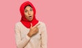 Young african american woman wearing traditional islamic hijab scarf surprised pointing with finger to the side, open mouth amazed Royalty Free Stock Photo