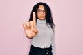 Young african american woman wearing turtleneck sweater and glasses over pink background Pointing with finger up and angry Royalty Free Stock Photo