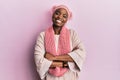 Young african american woman wearing wool hat and winter scarf happy face smiling with crossed arms looking at the camera Royalty Free Stock Photo
