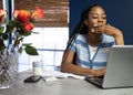 Young, African American woman working from home on her laptop in the kitchen Royalty Free Stock Photo