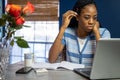 Young, African American woman working from home on her laptop in the kitchen Royalty Free Stock Photo