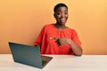 Young african american woman working at the office with laptop smiling happy pointing with hand and finger Royalty Free Stock Photo