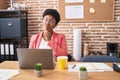 Young african american woman working at the office wearing glasses thinking concentrated about doubt with finger on chin and Royalty Free Stock Photo