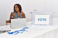 Young african american woman working at political election sitting by ballot doing money gesture with hands, asking for salary