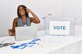 Young african american woman working at political election sitting by ballot smiling pointing to head with one finger, great idea