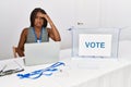 Young african american woman working at political election sitting by ballot worried and stressed about a problem with hand on Royalty Free Stock Photo